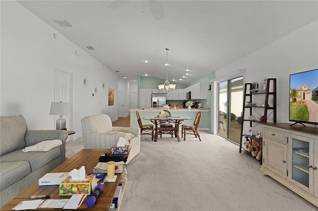 living room with light carpet, ceiling fan with notable chandelier, and lofted ceiling