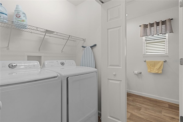 laundry area with washing machine and dryer and hardwood / wood-style flooring