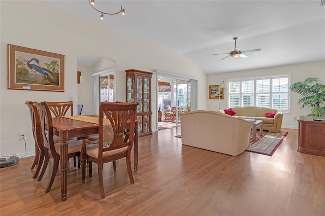 dining space with light hardwood / wood-style floors, vaulted ceiling, and ceiling fan