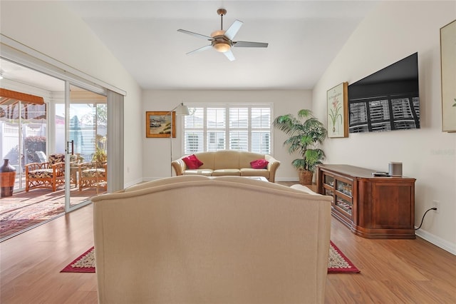 living room with light wood-type flooring, vaulted ceiling, and plenty of natural light