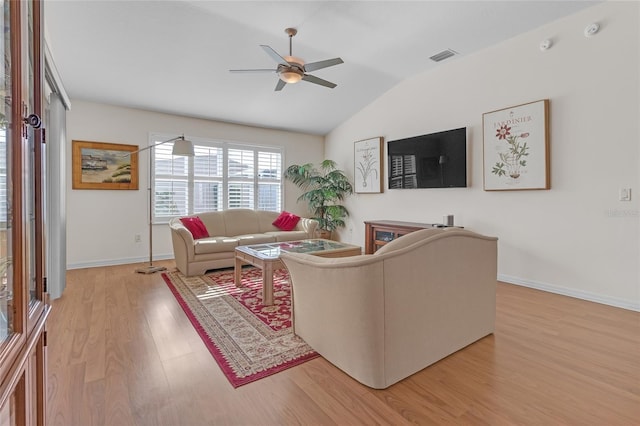 living room with ceiling fan, light hardwood / wood-style floors, and vaulted ceiling