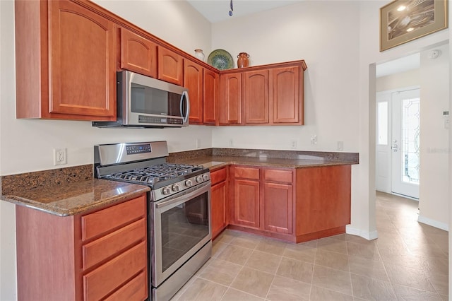 kitchen with dark stone countertops and appliances with stainless steel finishes