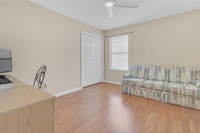 office with light wood-type flooring and ceiling fan