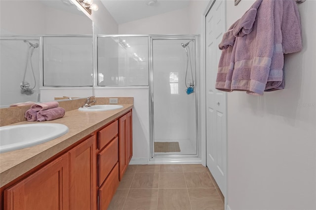 bathroom with tile patterned floors, vanity, a shower with door, and vaulted ceiling