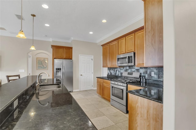 kitchen featuring sink, hanging light fixtures, dark stone countertops, light tile patterned floors, and stainless steel appliances