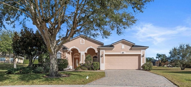 view of front of house featuring a garage and a front lawn