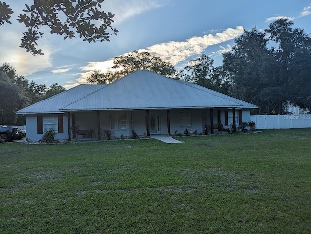 exterior space featuring covered porch and a yard