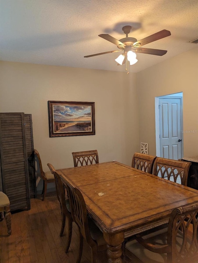 dining area featuring ceiling fan, dark hardwood / wood-style floors, and a textured ceiling