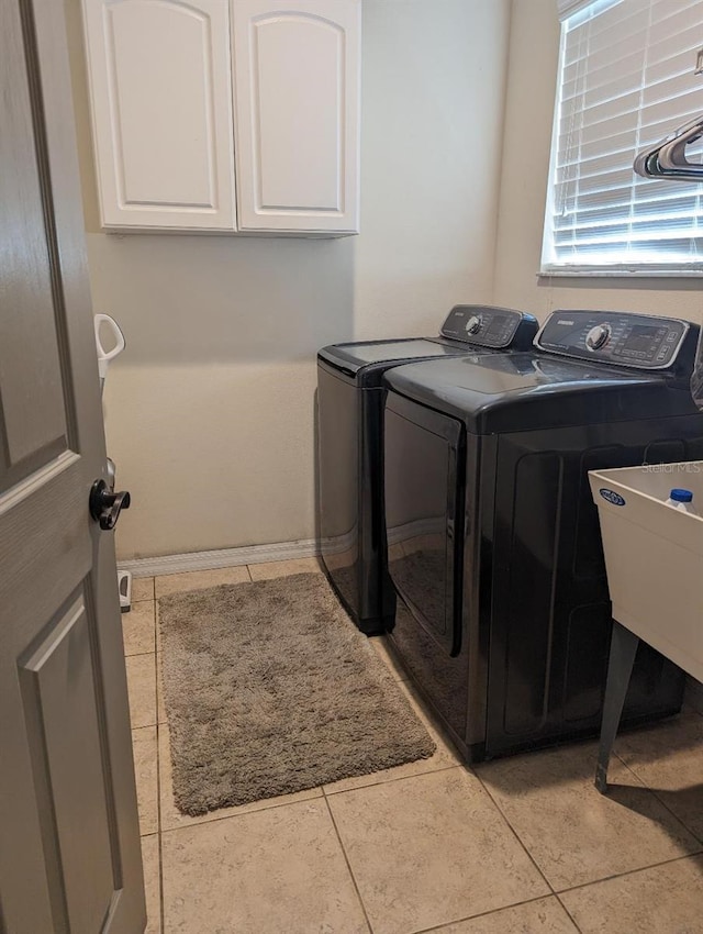 laundry room featuring washer and clothes dryer, light tile patterned flooring, cabinets, and sink