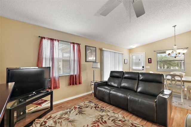 living room with vaulted ceiling, a textured ceiling, a wealth of natural light, and hardwood / wood-style flooring