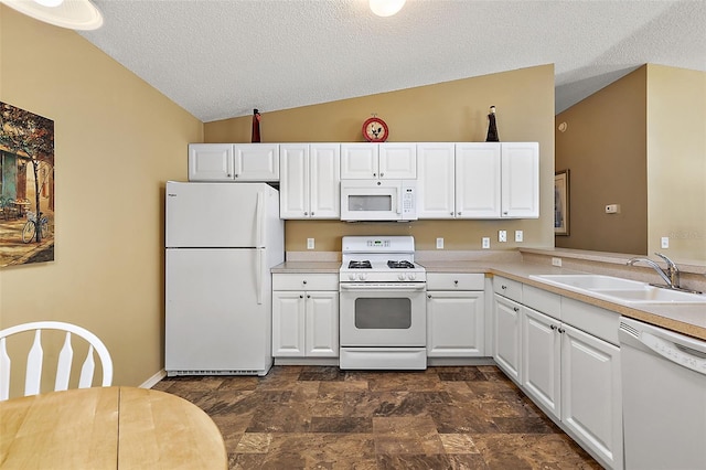 kitchen with sink, white cabinets, a textured ceiling, vaulted ceiling, and white appliances