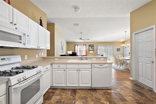 kitchen featuring white appliances, kitchen peninsula, sink, white cabinets, and ceiling fan with notable chandelier