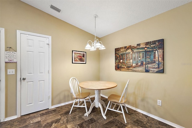 dining area featuring a notable chandelier and vaulted ceiling