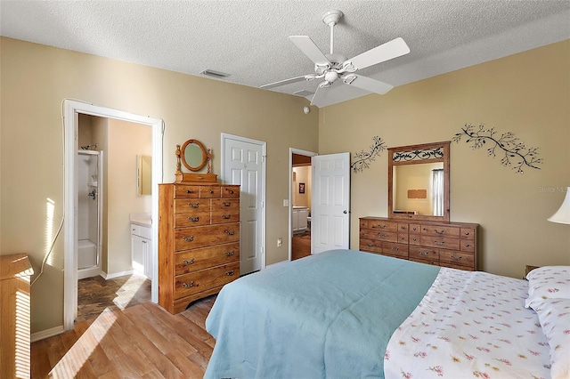 bedroom with connected bathroom, a textured ceiling, ceiling fan, and hardwood / wood-style flooring