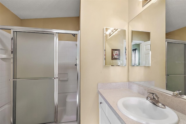 bathroom with lofted ceiling, an enclosed shower, vanity, and a textured ceiling