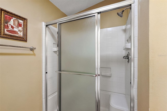 bathroom featuring a textured ceiling and walk in shower