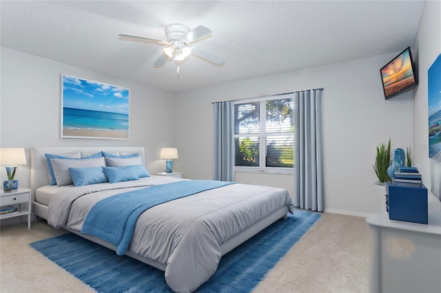 carpeted bedroom featuring ceiling fan and a textured ceiling