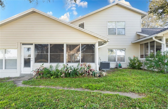 rear view of property with a yard and central AC