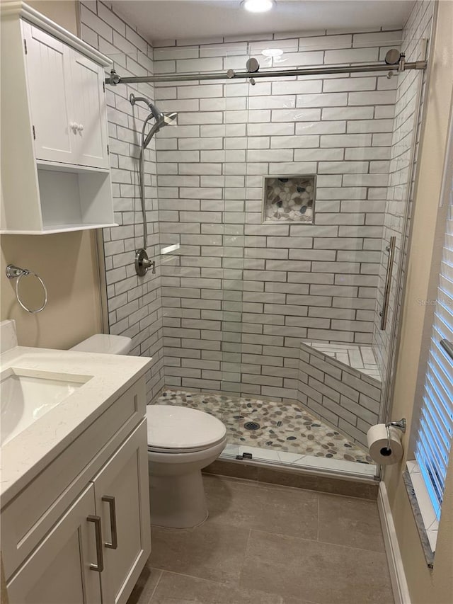 bathroom with toilet, a stall shower, and vanity