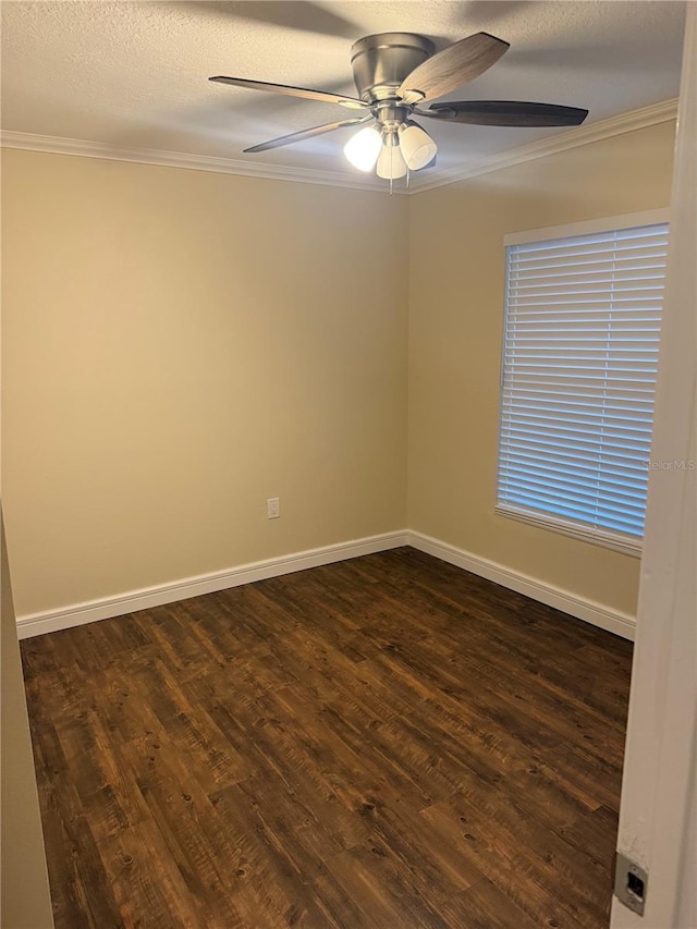 empty room with baseboards, a ceiling fan, dark wood finished floors, and crown molding