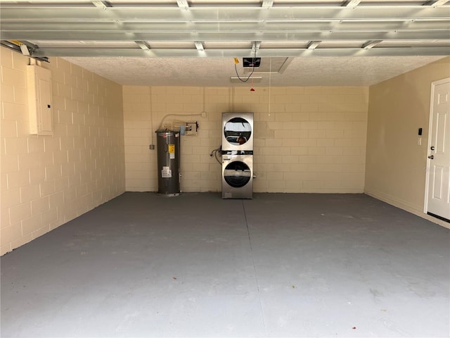 garage featuring concrete block wall, electric panel, water heater, stacked washer / dryer, and a garage door opener