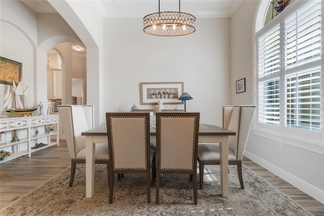 dining area featuring a notable chandelier, dark hardwood / wood-style flooring, and crown molding