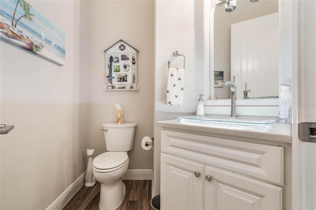 bathroom with hardwood / wood-style floors, vanity, and toilet