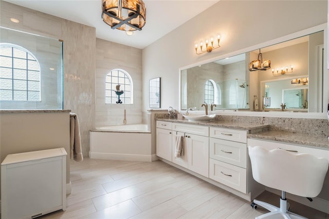 bathroom featuring tile patterned floors, a notable chandelier, plus walk in shower, and vanity