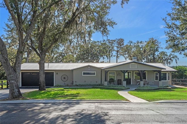 ranch-style home featuring a garage, a front yard, and covered porch