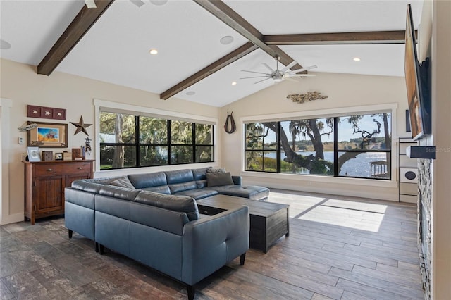 living area featuring lofted ceiling with beams, plenty of natural light, a ceiling fan, and dark wood-style flooring