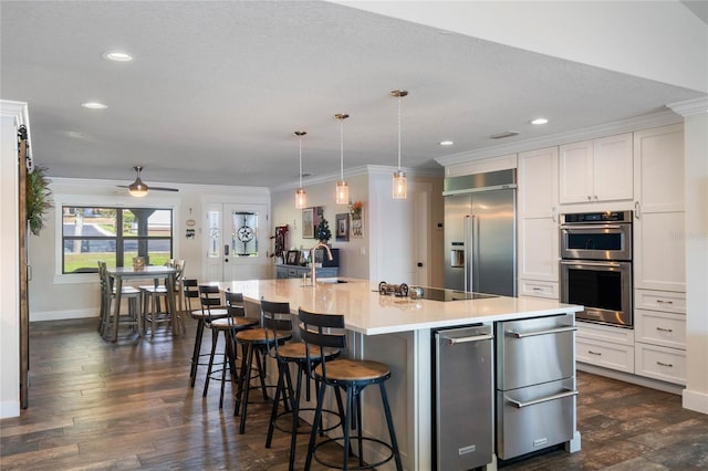 kitchen featuring a warming drawer, stainless steel appliances, crown molding, and white cabinets