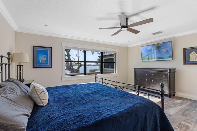 bedroom featuring crown molding, visible vents, a ceiling fan, wood finished floors, and baseboards