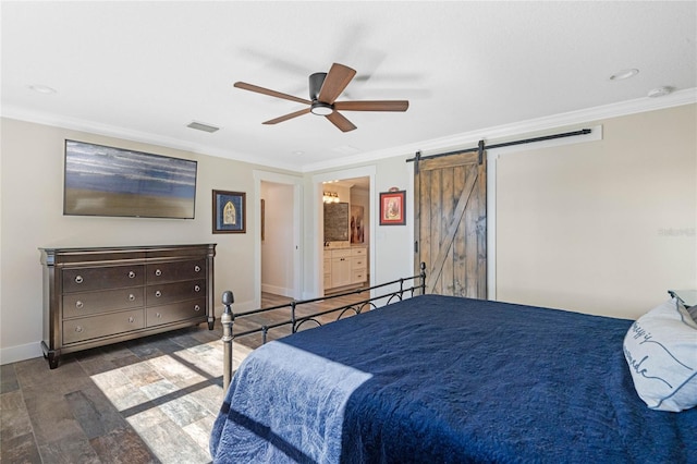 bedroom featuring baseboards, a barn door, visible vents, and crown molding