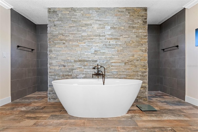 bathroom featuring a textured ceiling, wood finish floors, a soaking tub, and walk in shower