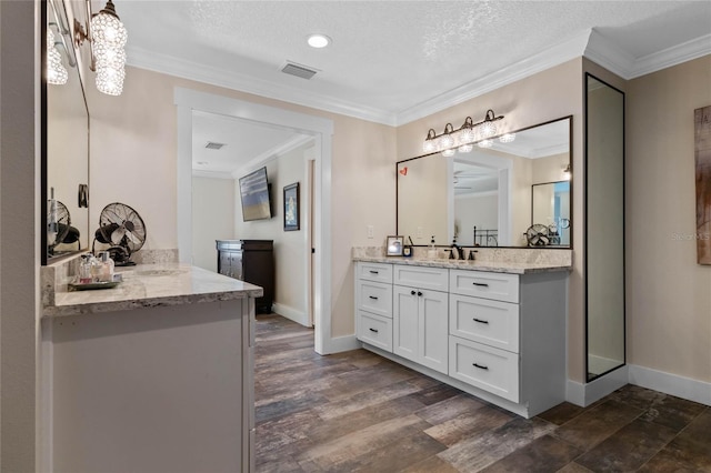 bathroom with wood finished floors, visible vents, and crown molding