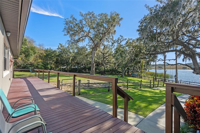 wooden deck featuring a lawn and a water view