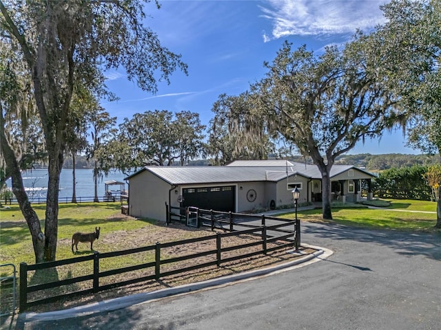 ranch-style house with metal roof, driveway, and a garage