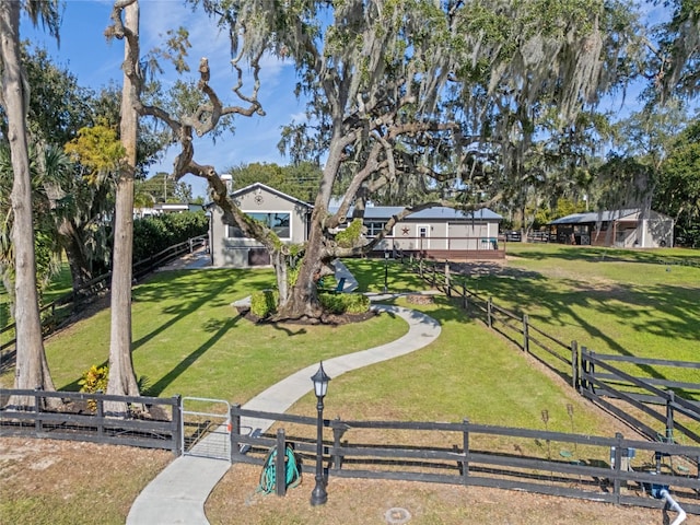 view of property's community with a fenced front yard, a gate, and a yard