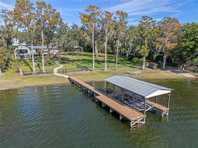 view of dock with a water view, a yard, and boat lift