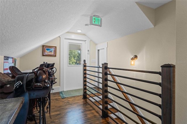 additional living space featuring a textured ceiling, dark wood-type flooring, and vaulted ceiling