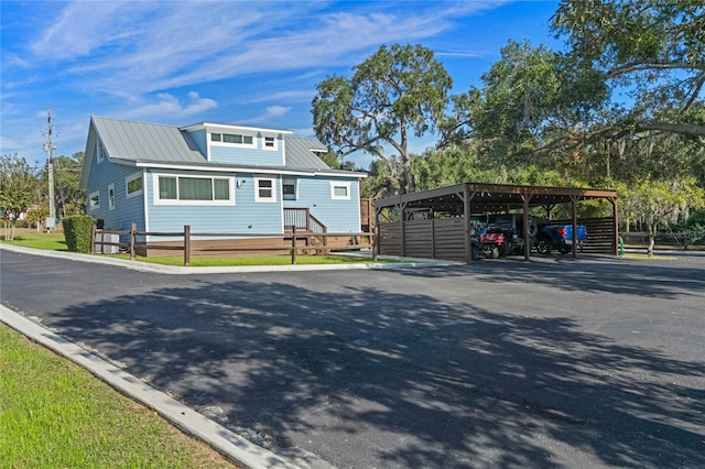 view of front of property with fence, metal roof, and a detached carport