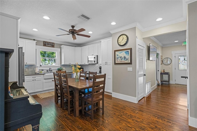 dining room with dark wood-style floors, ornamental molding, visible vents, and baseboards