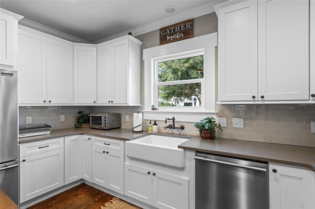 kitchen with dark wood-style floors, tasteful backsplash, appliances with stainless steel finishes, white cabinetry, and a sink