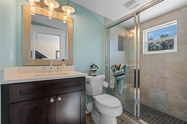 full bathroom with visible vents, a shower stall, toilet, and vanity