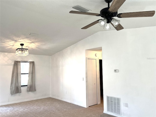 carpeted spare room with a textured ceiling, ceiling fan, and lofted ceiling