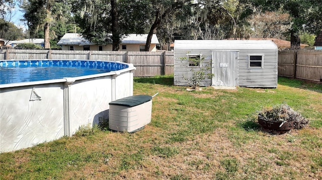 view of yard featuring a fenced in pool, a storage shed, and a fire pit