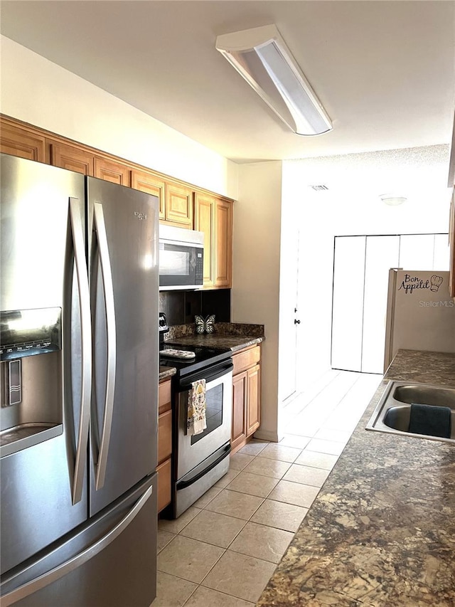 kitchen featuring appliances with stainless steel finishes and light tile patterned floors