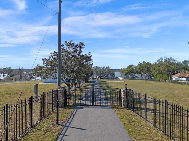 view of gate with a lawn