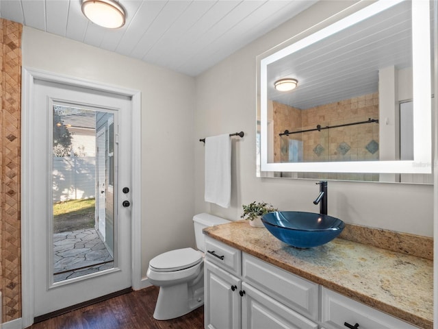 bathroom featuring toilet, vanity, and hardwood / wood-style floors