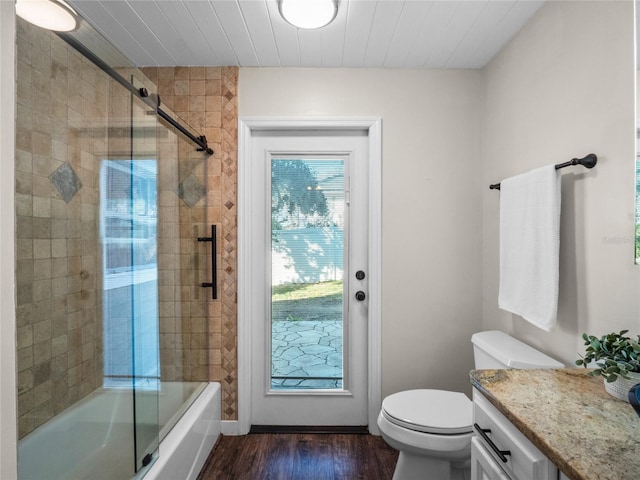 full bathroom featuring shower / bath combination with glass door, toilet, wood-type flooring, and vanity